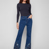 Indigo jeans with a flare fit and intricate floral lace at the hem, crafted from stretch denim for comfort by Charlie B.