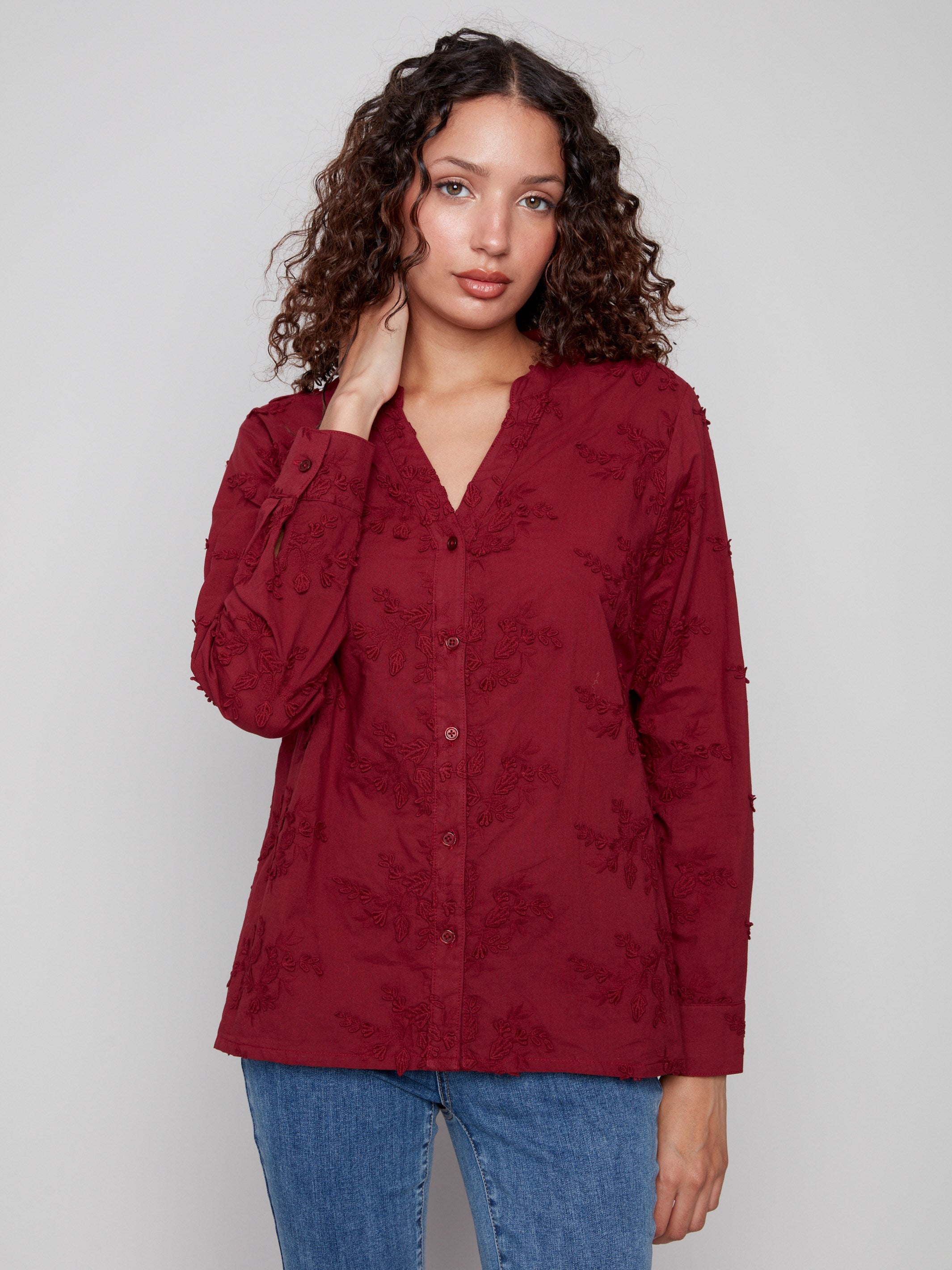 This cabernet blouse showcases exquisite applique flowers adding a touch of elegance to your wardrobe by Charlie B.