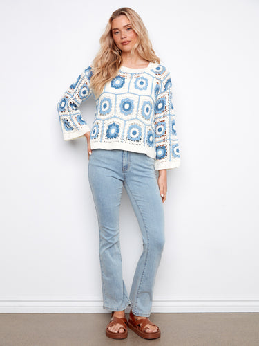 Chic long-sleeved sweater showcasing an elegant boat neckline and beautiful crochet design by Charlie B.