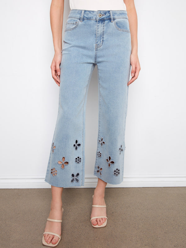 Denim jeans in light blue featuring a wide leg and intricate floral cutouts at the hem for added flair by Charlie B.