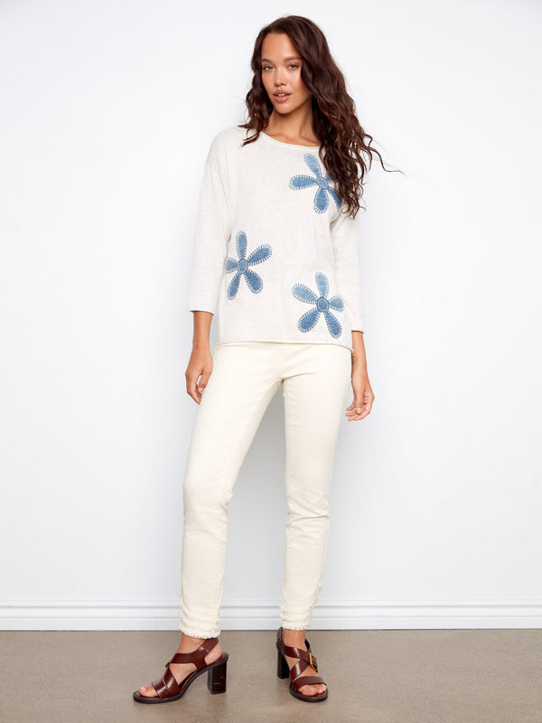 This 100% cotton sweater features charming floral embroidery, adding a touch of elegance to your look by Charlie B.