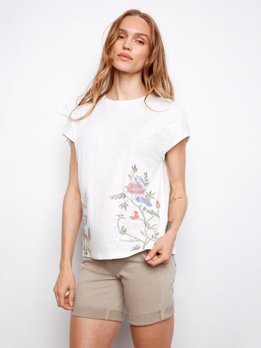 This white T-shirt features intricate floral embroidery on the sides, crafted from pure cotton by Charlie B.