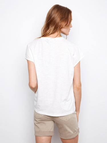 The soft 100% cotton material complements the floral design on this elegant white tee by Charlie B.