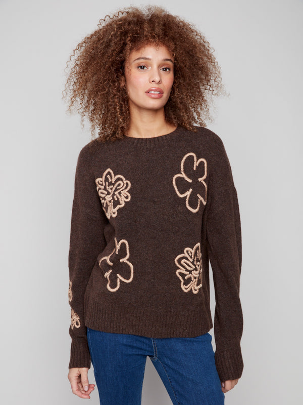 Brown sweater with floral embroidery, showcasing drop shoulders and ribbed cuffs for a cozy look by Charlie B.