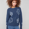 Denim sweater with a crew neck, showcasing a charming embroidered floral design, complemented by ribbed cuffs. By Charlie B.