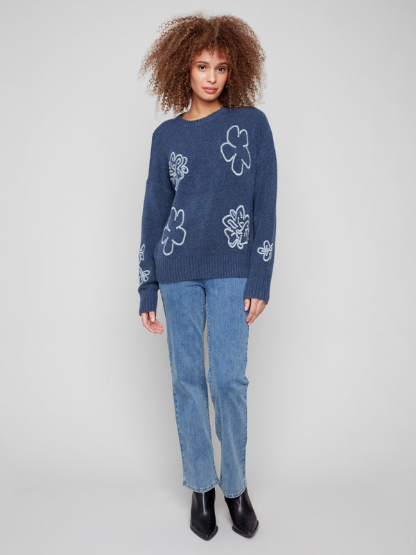 This stylish denim sweater features drop shoulders and an intricate floral embroidery, complete with ribbed hem. By Charlie B.