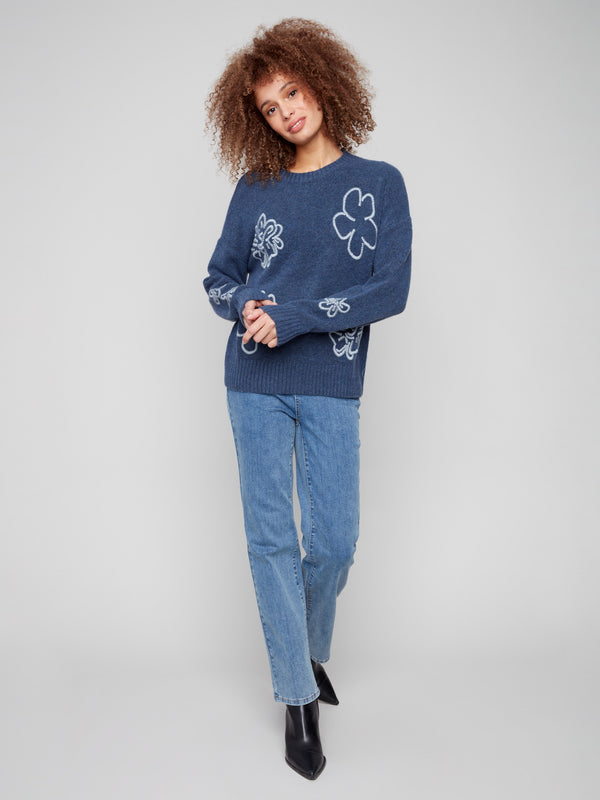 Heathered denim sweater featuring exquisite floral embroidery and finished with a chic crew neck design. By Charlie B.