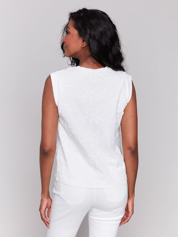 Embroidered floral patterns on white top by Charlie B.