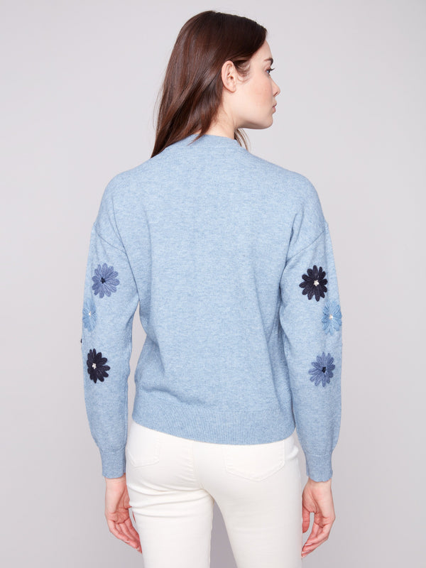 Elegant heather denim sweater with floral embroidery, crafted in a relaxed fit to enhance comfort by Charlie B.