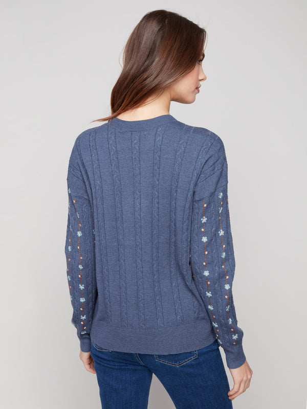 Tulip-colored sweater crafted from luxurious cable plush knit, highlighted by ribbed cuffs and floral details by Charlie B.