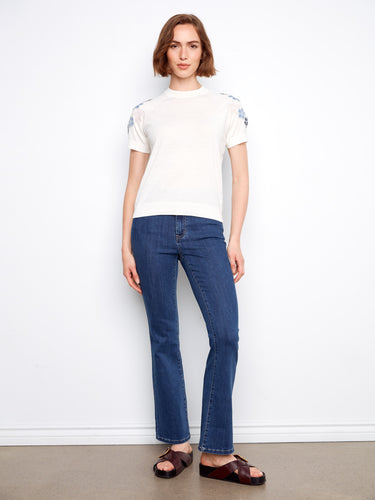Elevate your wardrobe with this elegant white top, featuring raglan sleeves and exquisite flower embroidery for a touch of charm by Charlie B.