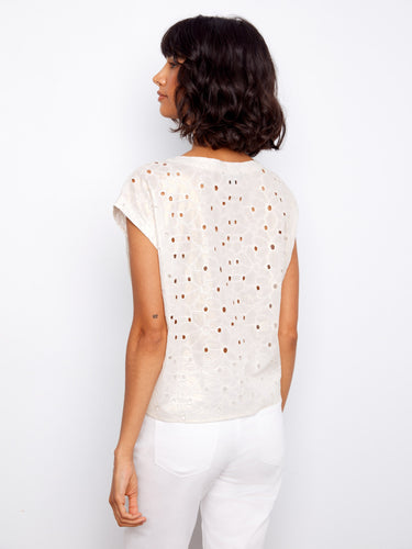 The tie-front detail complements the boat neckline, making this gold foiled eyelet blouse versatile and trendy by Charlie B.