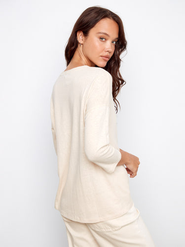 Stylish relaxed fit garment showcasing an eye-catching foiled effect, complemented by its elegant V-neck style. By Charlie B.