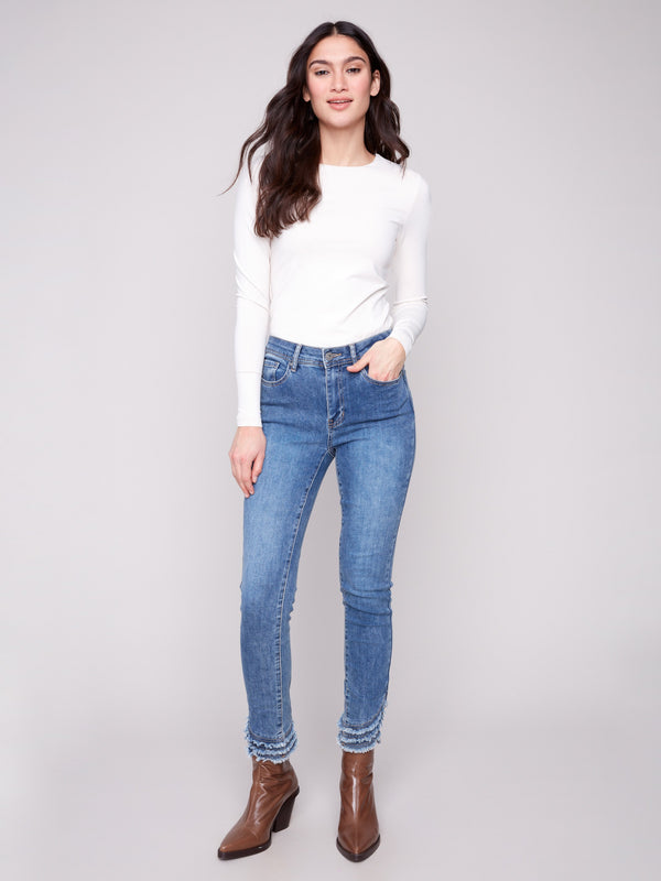 Medium blue denim pants with frayed hem, featuring a skinny leg and regular rise by Charlie B.