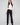 Black flare pants featuring long length, paired with a white top, by Charlie B.