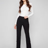 Black flare pants featuring long length, paired with a white top, by Charlie B.