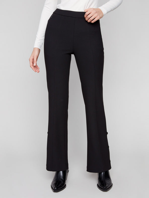 Stylish black flare pants showcasing welt pockets, worn with a white top, by Charlie B.
