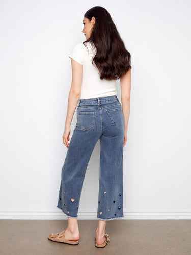 Wide-leg jeans in medium blue with classic five-pocket styling and adorable heart cutouts at the hem by Charlie B.