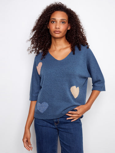 Featuring elbow sleeves, this blue sweater offers comfort and style with its playful heart accents and relaxed silhouette. By Charlie B.