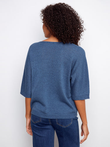 A stylish blue sweater highlighted by lurex thread detailing, offering both elegance and comfort in its relaxed fit design. By Charlie B.