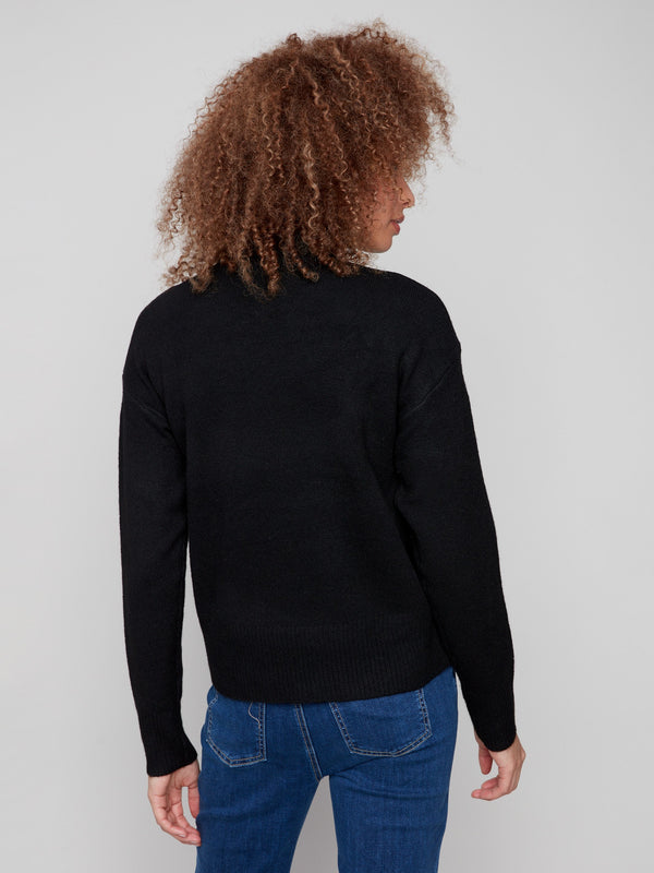 Ribbed shoulders add texture and detail to this elegant black sweater with a white heart by Charlie B.