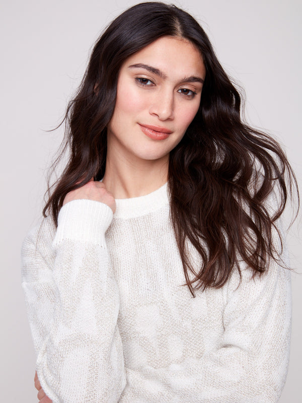 Elegant off-white sweater with ribbed cuffs and a classic crew neckline, showcasing subtle tonal text by Charlie B.
