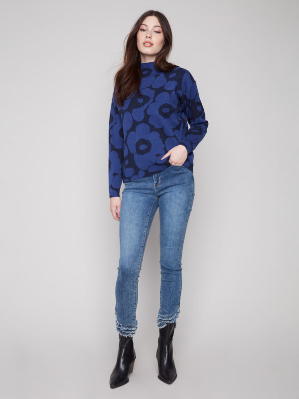 Stylish blue aura sweater featuring long sleeves and a striking floral pattern by Charlie B.