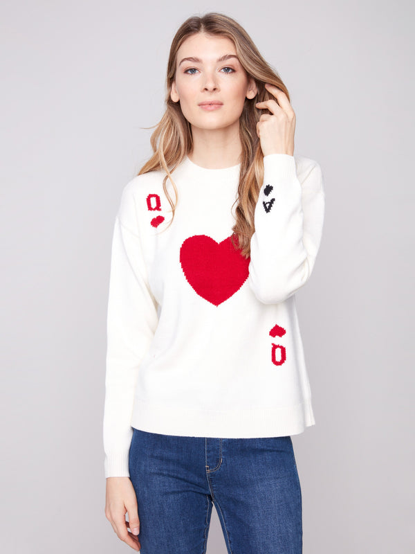 White plush knit sweater with a ribbed hem, showcasing red and black graphics by Charlie B.