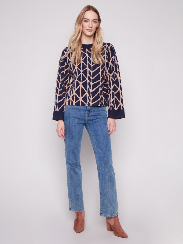 Stylish navy sweater showcasing folded cuffs and intricate jacquard design, perfect for versatile styling by Charlie B.