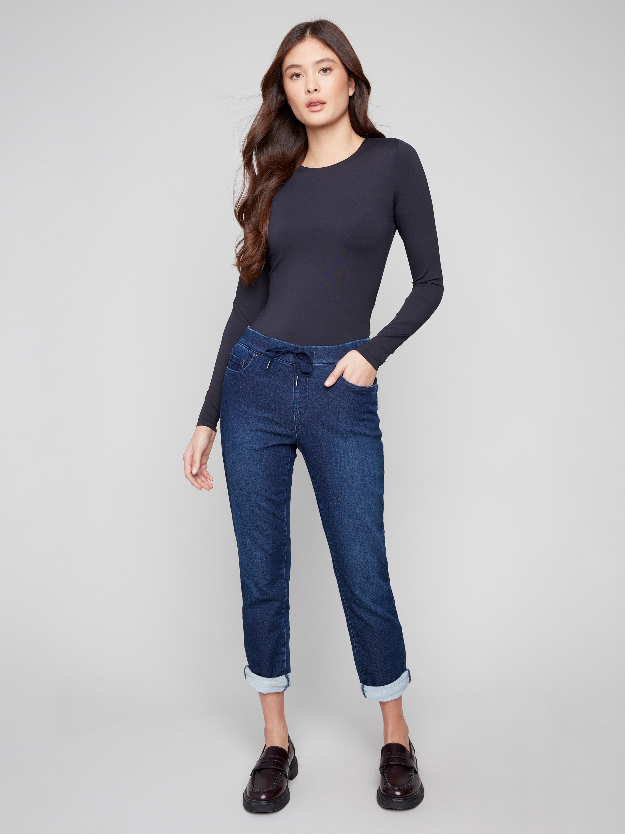 Indigo denim jogger pants featuring a slim leg and elastic waistband, paired with rolled cuffs for a chic look by Charlie B.