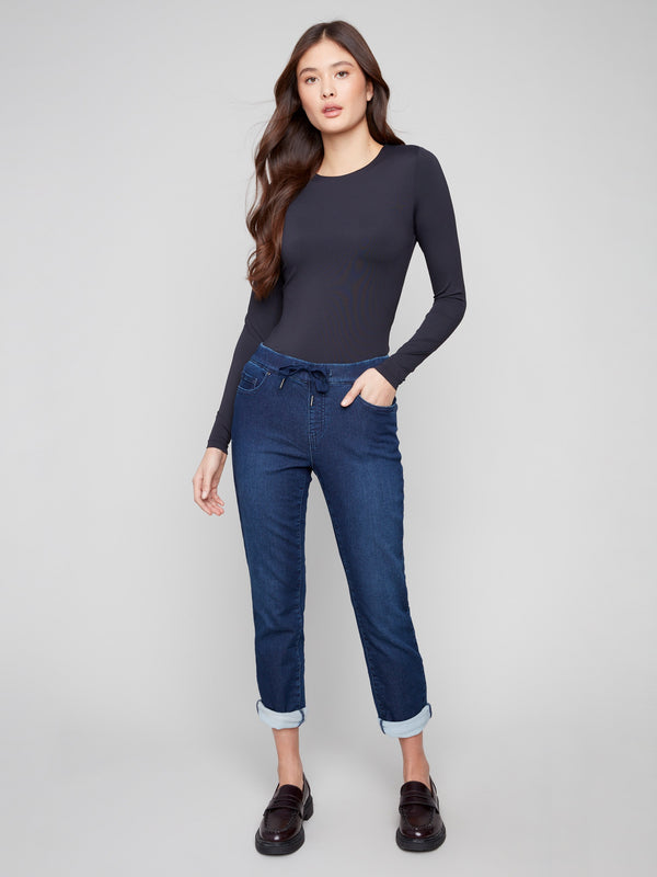 Indigo denim jogger pants featuring a slim leg and elastic waistband, paired with rolled cuffs for a chic look by Charlie B.