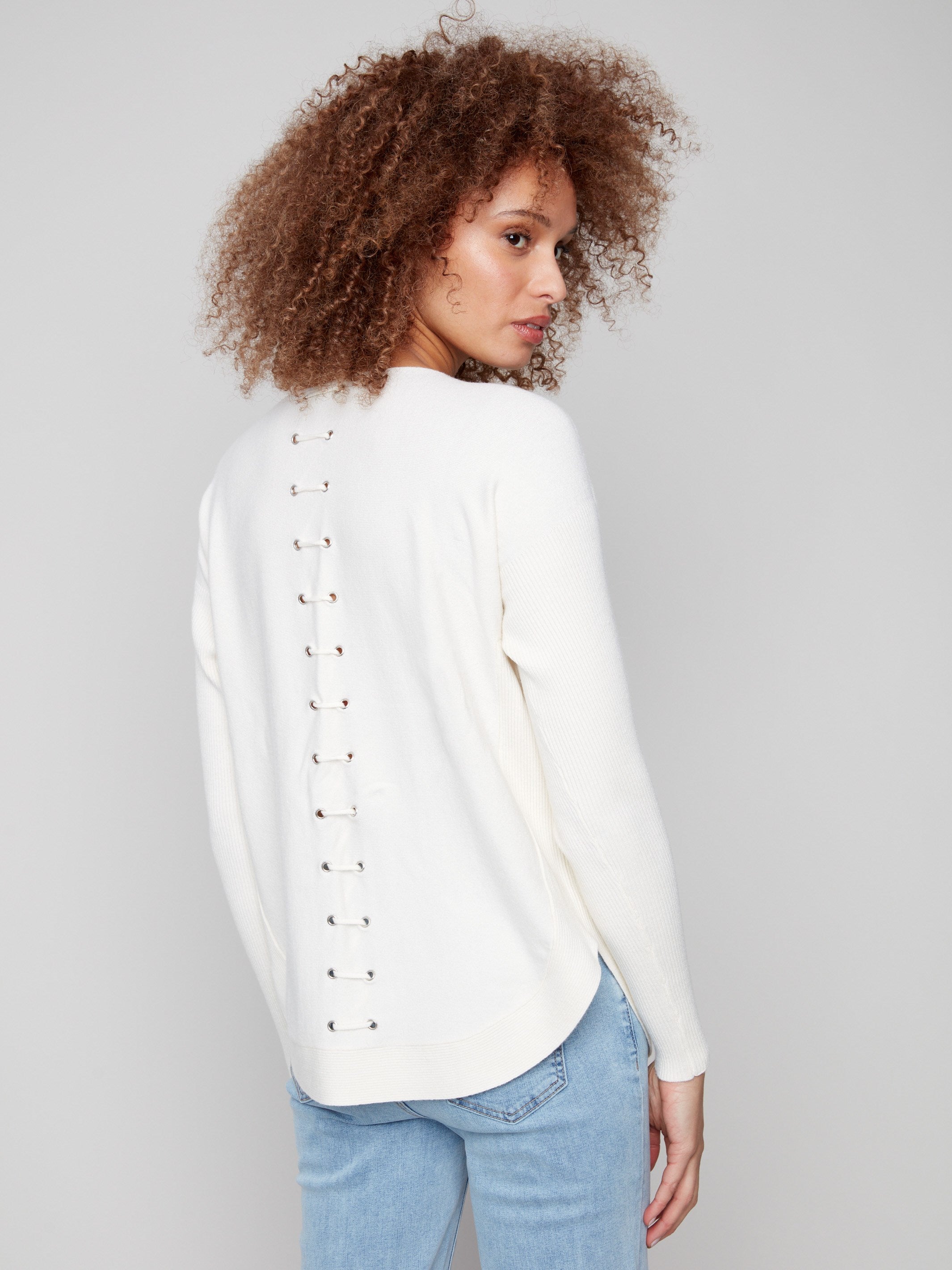 Elegant ecru knit sweater showcasing intricate back lace-up eyelet details for added flair by Charlie B.