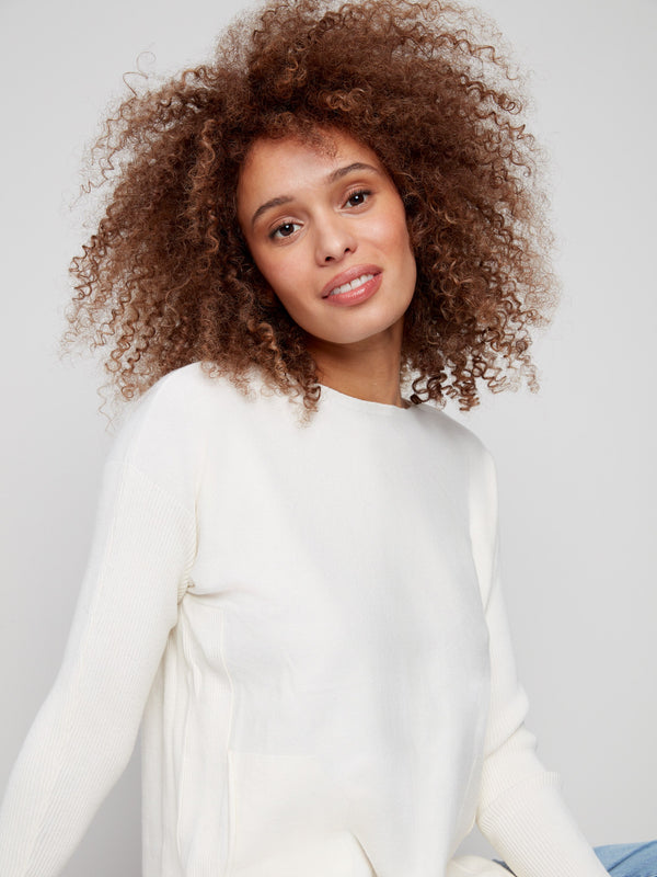 This ecru knit sweater includes practical front pockets, combining functionality with chic design by Charlie B.