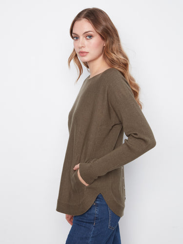 The long ribbed sleeves on this olive sweater provide both comfort and style, making it ideal for layering. By Charlie B.