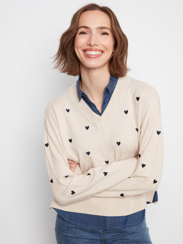 Embroidered heart pattern on long sleeves of Heather Oat sweater, crafted for style by Charlie B.