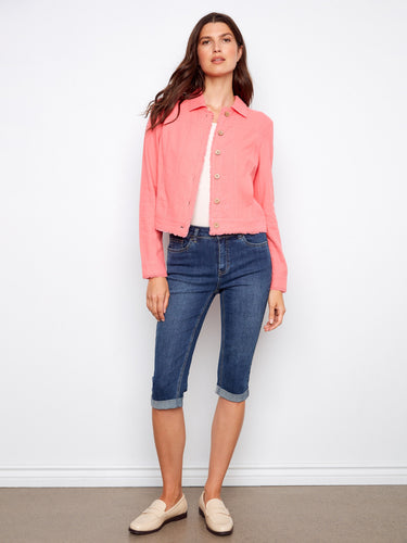 A vibrant pink jacket with a short length, paired with denim capris. The look is casual yet chic by Charlie B.