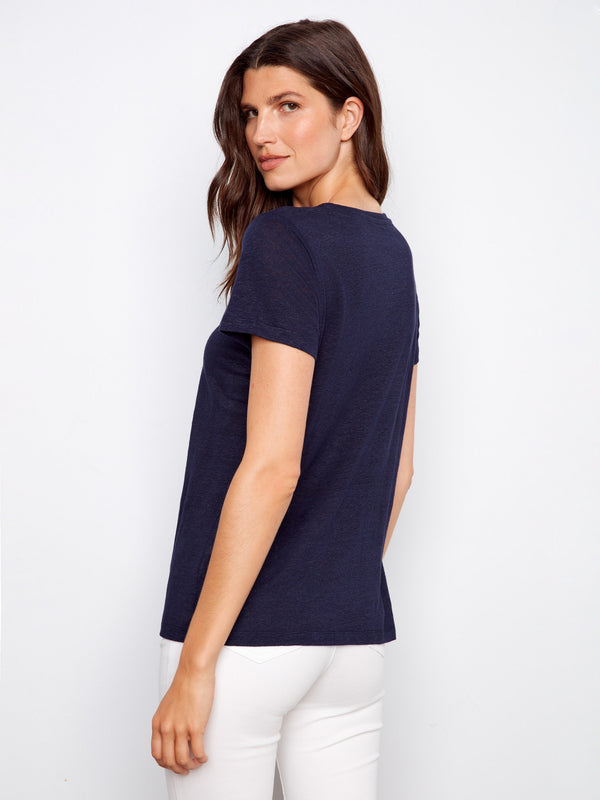 Navy V-neck T-shirt featuring short sleeves and a chic look with white pants by Charlie B.