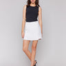 White linen blend skort featuring a short length, styled with a black sleeveless top by Charlie B.