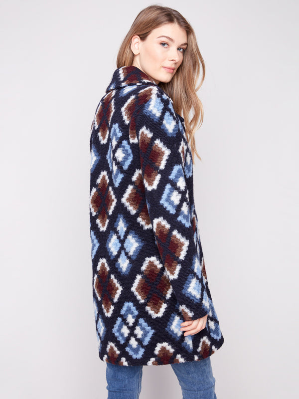 Elegant crochet coat in twilight with a bold geometric pattern, highlighted by its tailored collar by Charlie B.