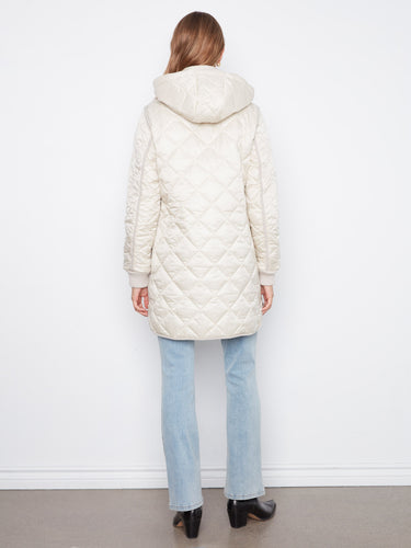 Chic quilted coat featuring a front zip closure with snap buttons for added convenience and style. Fashion forward by Charlie B.