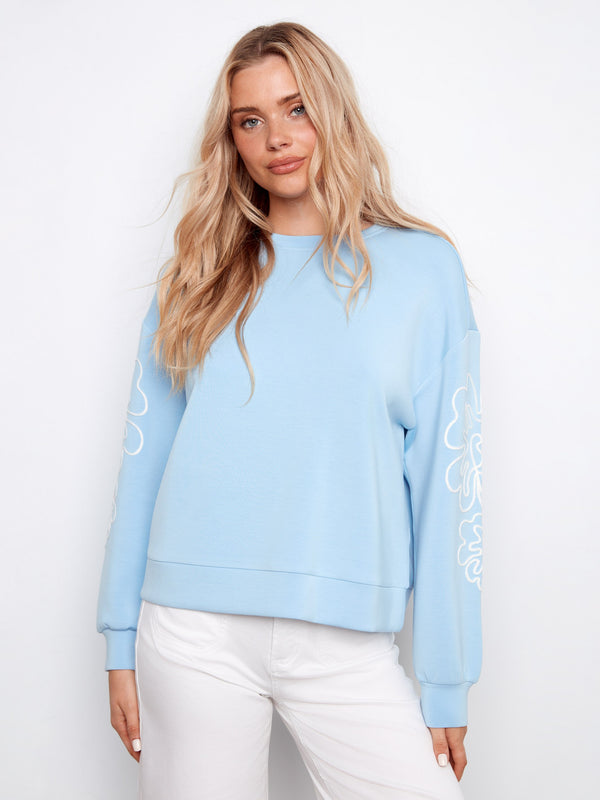 Light blue scuba top featuring a relaxed fit and soutache detail on sleeves by Charlie B.