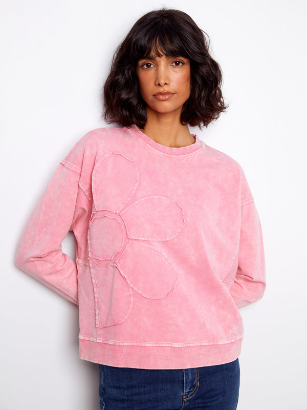 Pink sweatshirt featuring a ribbed neck, hem, and cuffs with a charming flower applique design. Perfect for casual outings. By Charlie B.