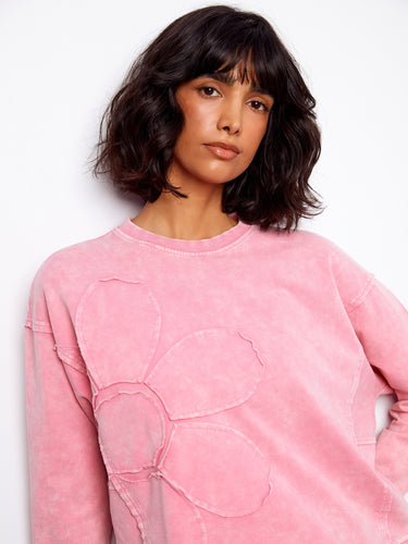 Cozy pink sweatshirt showcasing a crew neckline and intricate flower applique for a touch of elegance in everyday wear. By Charlie B.