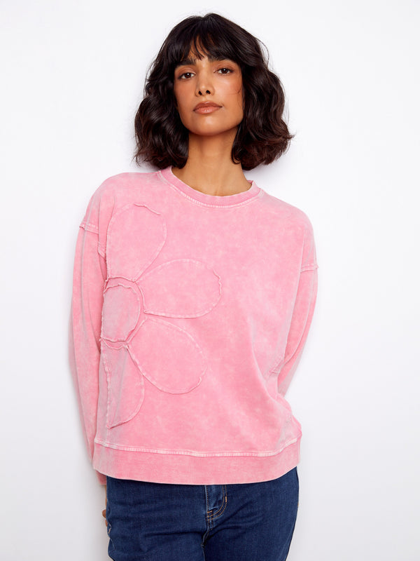 Trendy pink top highlighting drop shoulders and an artistic flower applique pattern for fashionable comfort. By Charlie B.