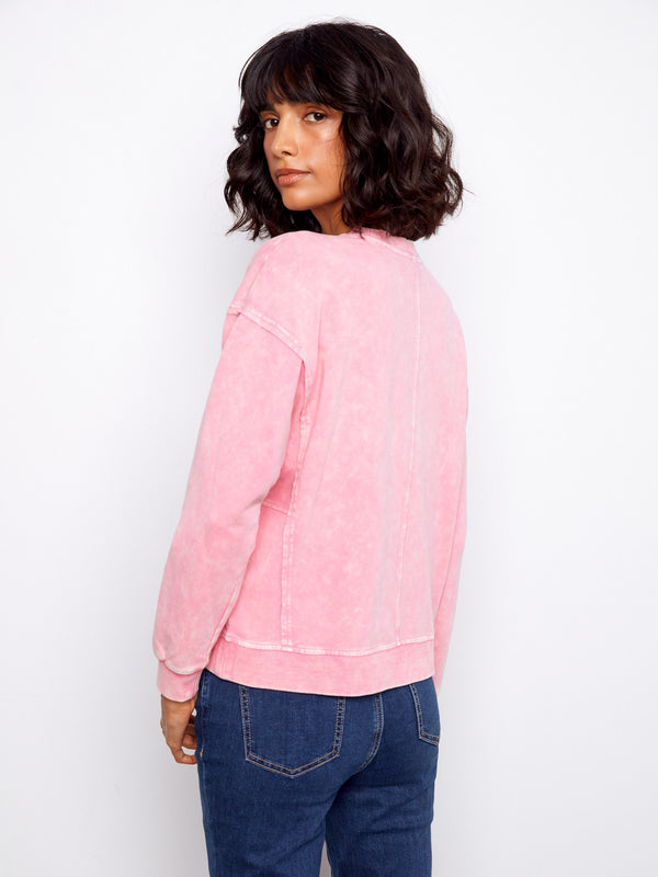 Comfortable pink sweatshirt crafted with ribbed details at the neck, hem, and cuffs along with a stunning floral design. By Charlie B.