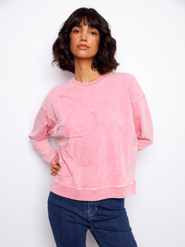 Elegant pink sweater featuring drop shoulders paired beautifully with an artistic flower applique motif for style lovers. By Charlie B.