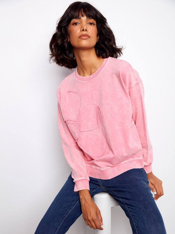 Casual yet stylish pink pullover designed with crew neckline and distinctive floral details to enhance any look effortlessly. By Charlie B.