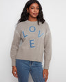 Sweater featuring a mock neck with a stylish denim LOVE appliqué, perfect for casual outings. Designed by Charlie B.
