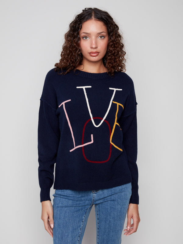 Navy sweater featuring colorful 'LOVE' embroidery in a playful design, paired with ribbed cuffs for added style by Charlie B.