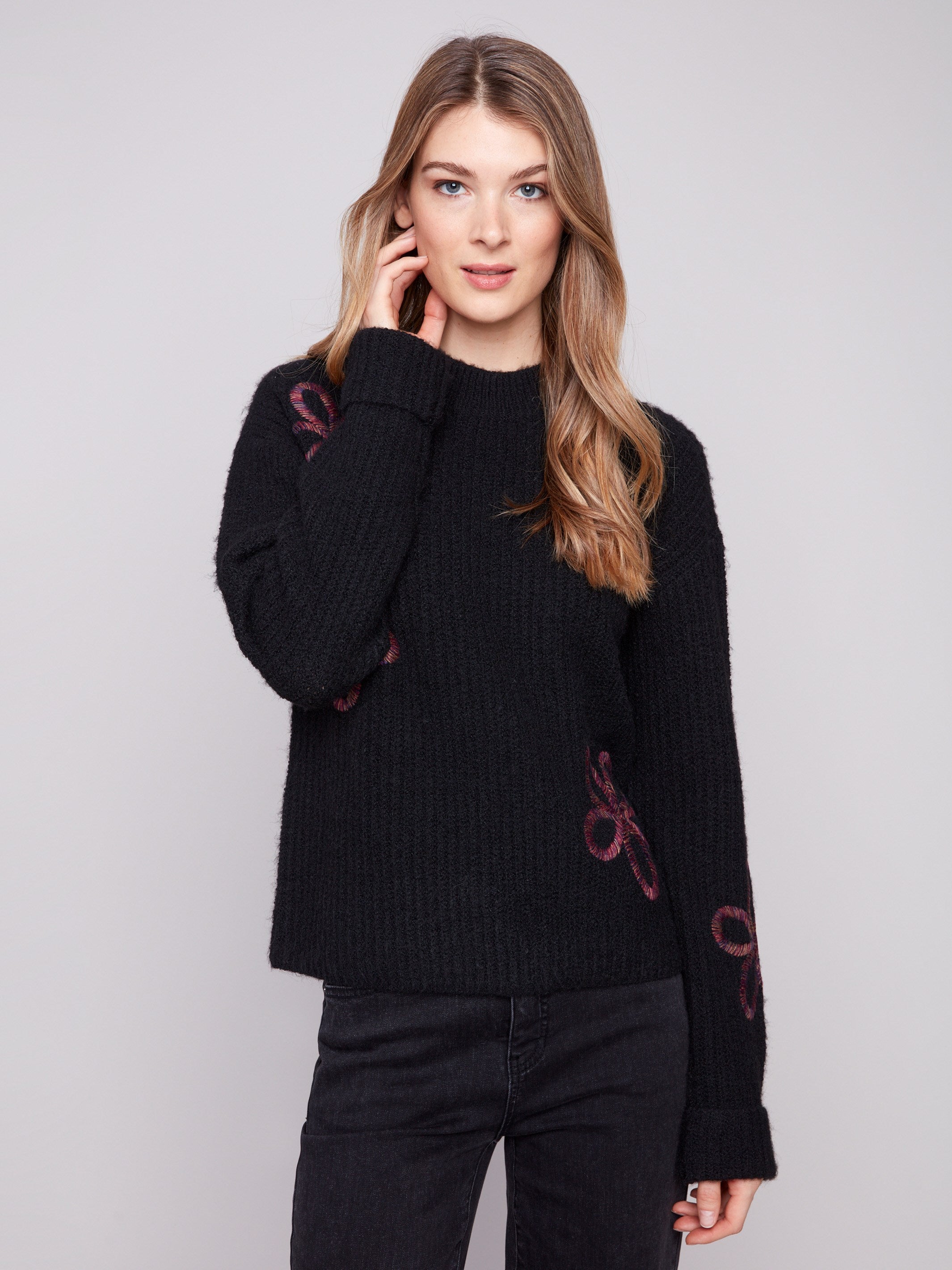Elegant black sweater adorned with unique floral soutache details and wide cuffs by Charlie B.